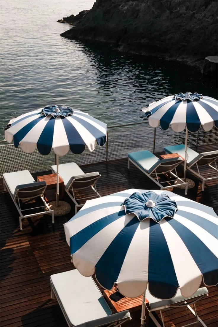 Parasols rayés bleu et blanc d'une plage privée face à la mer
